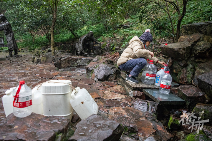 220201czq39 虎跑公园,虎跑泉取水口,市民拿着大桶小桶前来取水.
