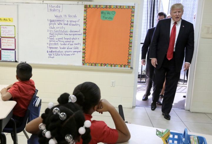 President Donald Trump, right, arrives in a classroom at St. Andrew Catholic School in Orlando, Fla., on March 3, 2017.